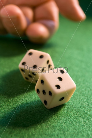 hand rolling dice onto a green baize