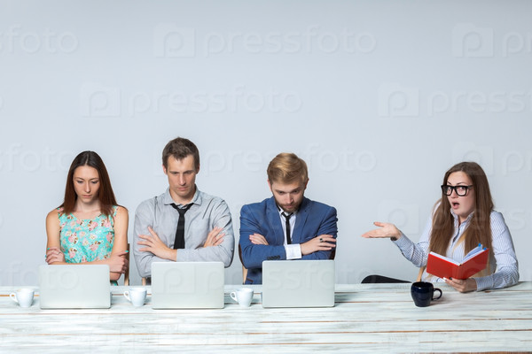 Business team working together at office on light gray background. all working on laptops. boss giving a task, all thinking. copyspace image