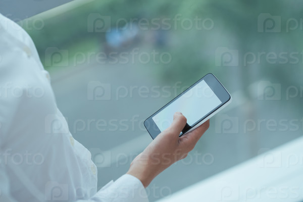 Woman using application on the smartphone, view over the shoulder