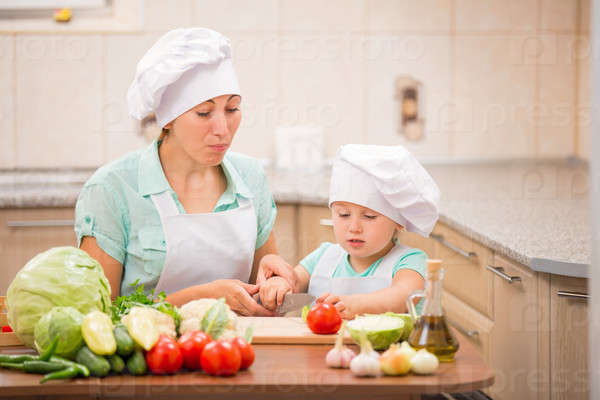 Mom with a child cooks in the kitchen