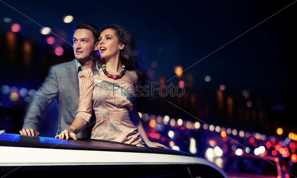 Fashionable pair of elegant people at night city street