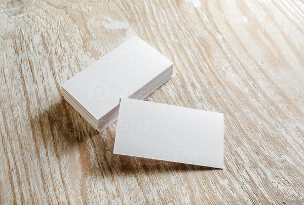 Photo of blank business cards on light wooden background. Mock-up for branding identity.