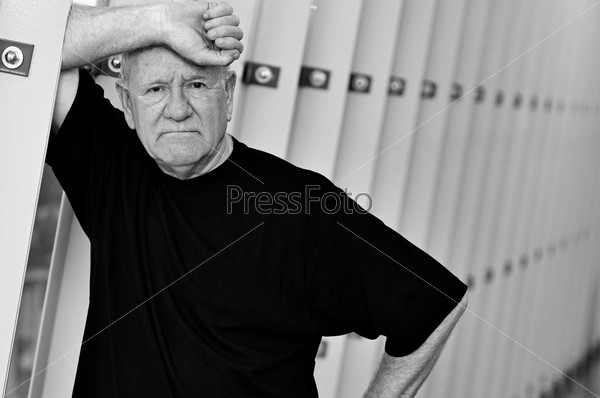 Older senior man leaning on wall