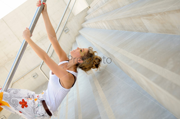 A woman hanging upside down from a handrail