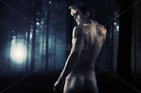 Fine art photo of a young muscular man  in a forest