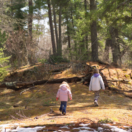 Rear view of two young girls walking in Lake of the woods, Ontario, Canada