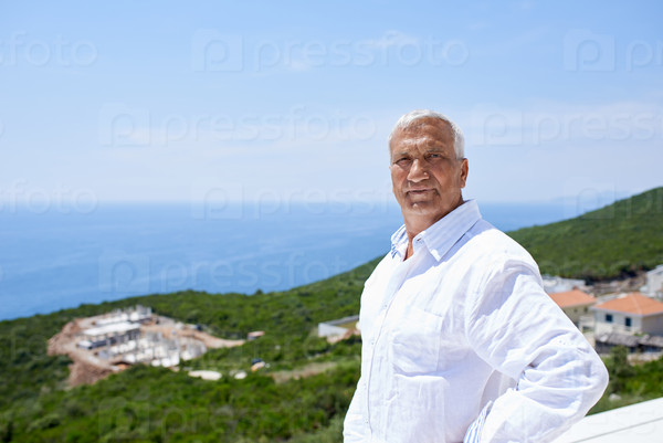senior man in front of modern home