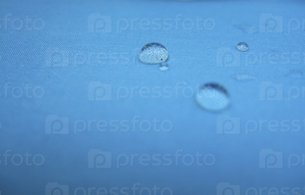 Water drops on blue fabric, closeup