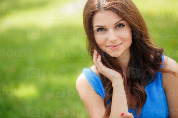 A portrait of a beautiful blonde young Caucasian woman outdoor. Young smiling woman outdoors portrait. Soft sunny colors.Close portrait.