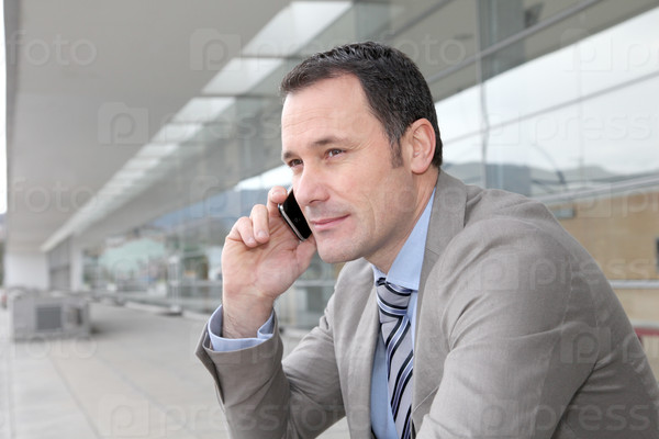 Salesman talking on the phone outside congress center