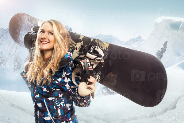 Portrait of a girl with a snowboard in the mountains