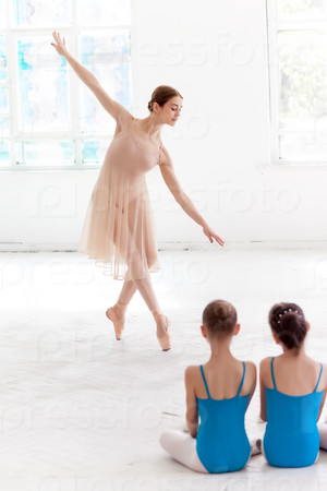Stock Photo: Two little ballerinas dancing with personal ballet teacher in dance studio