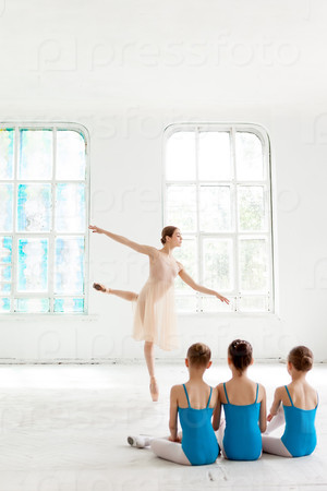 Stock Photo: Three little ballerinas dancing with personal ballet teacher in dance studio