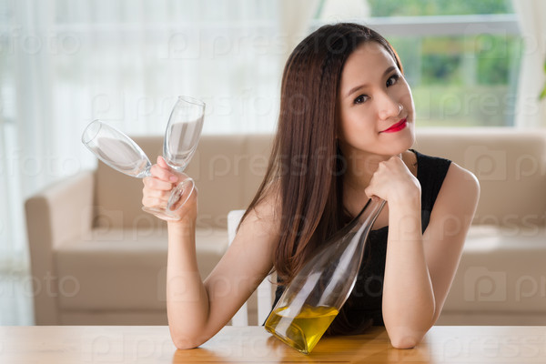Attractive Vietnamese woman with a bottle of champagne and two flutes