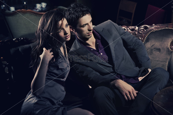 Young attractive couple sitting on sofa