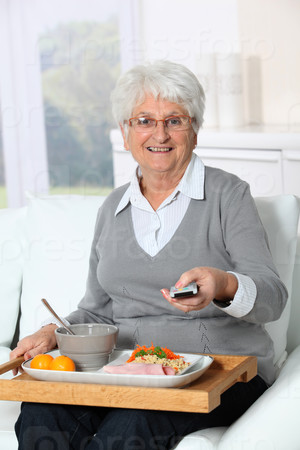 Elderly woman sitting in sofa  with lunch tray