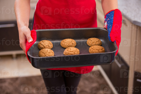 tray of homemade cookies in the hands of women