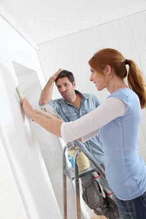 Couple choosing wallpaper color for new house