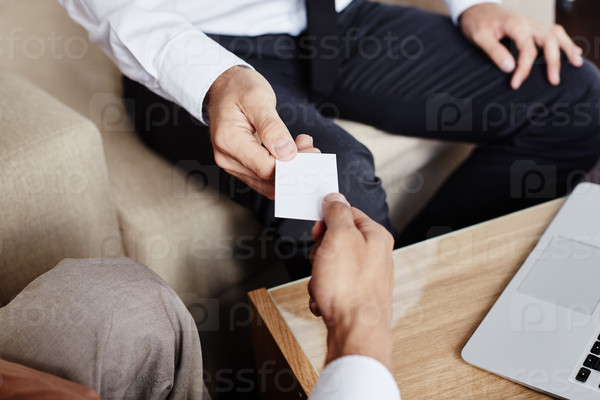 Male employee giving blank visiting card to new partner