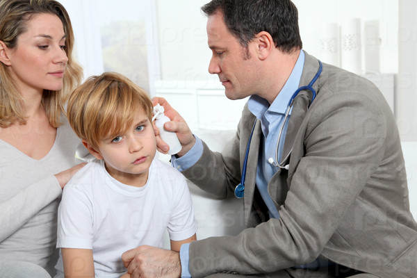 Doctor checking little boy\'s ear infection