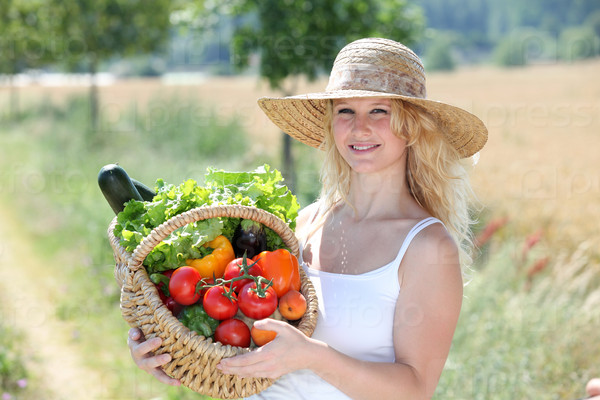 Красивая женщина, держащая корзина свежих овощей