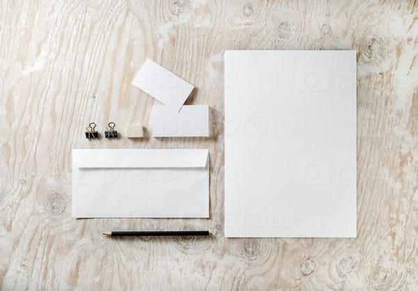 Photo of blank stationery set on light wooden background. Template for design presentations and portfolios.