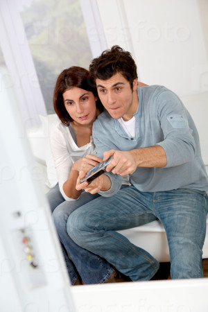 Couple playing video games at home