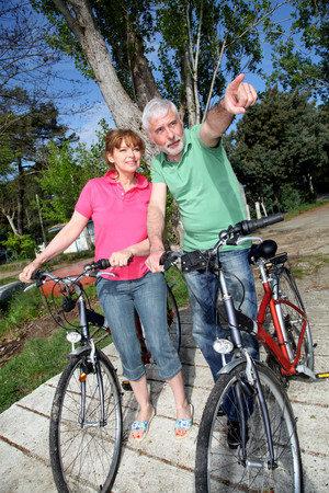 Пожилые супружеские пары на велосипеде ездить на озера