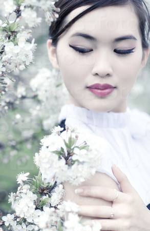 Young woman with cherry flowers. Birght white colors.