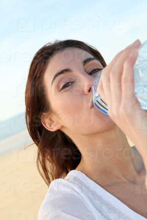 Closeup of woman drinking water from bottle