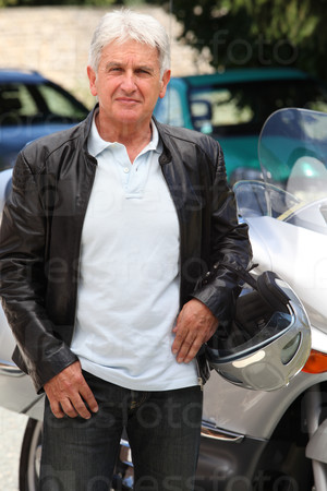 Senior man in front of motorcycle