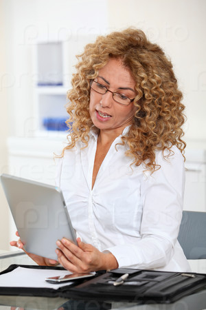 Businesswoman in office using electronic tab