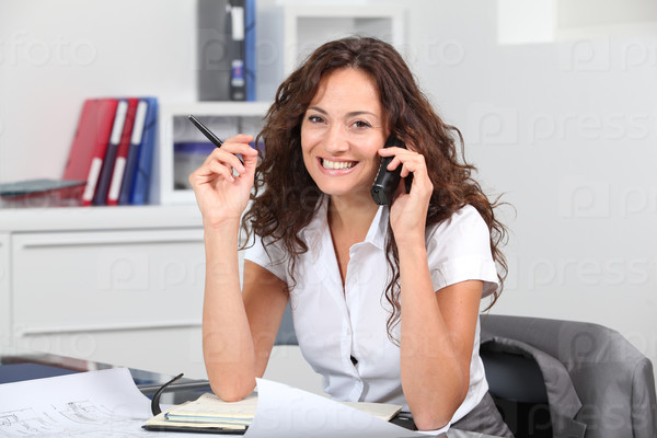 Closeup of businesswoman in the office talking on the phone