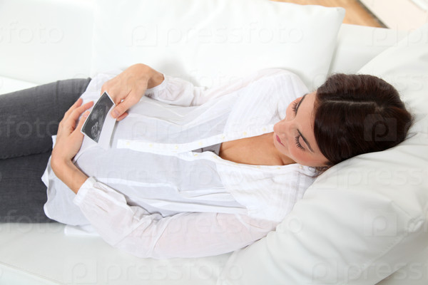 Pregnant woman looking at sonogram of future child