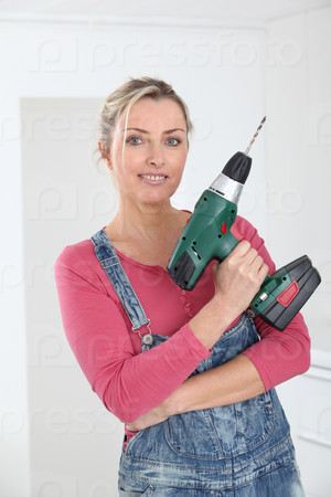Beautiful blond woman holding electric drill