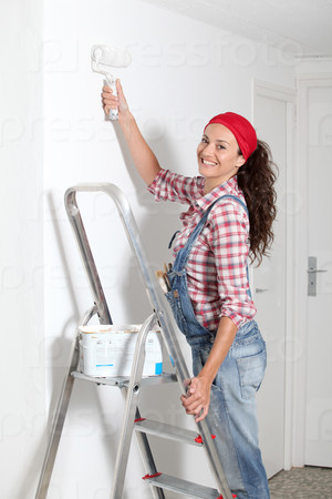 Woman painting the walls of new home