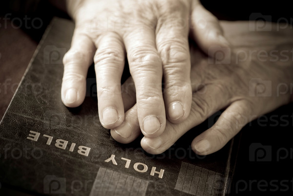 hands on the bible( focus point on fingers(selective))