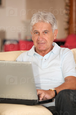 Closeup of senior man with laptop computer at home