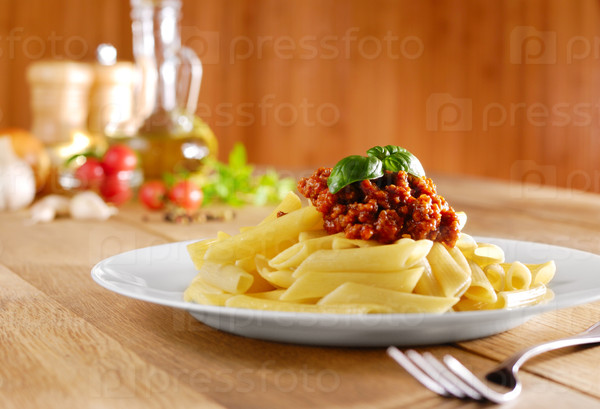Penne pasta with a tomato bolognese beef sauce on the kitchen table
