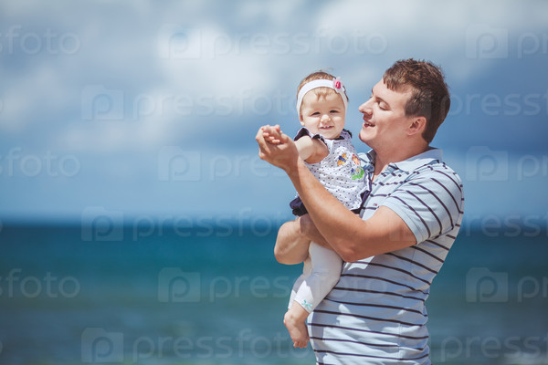 portrait of a Happy family of man and child having fun by the blue sea in summertime