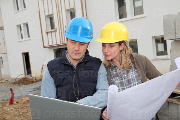 Архитектор и инженер, глядя на план по строительной площадке