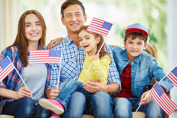 Modern American family with flags celebrating Independence Day
