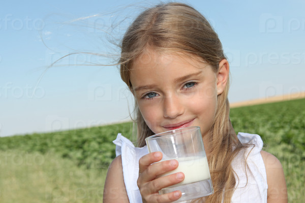 Closeup of little girl drinking milk, stock photo