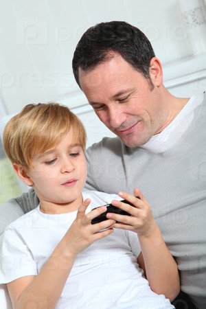 Father and son playing video game at home