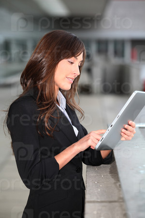 Businesswoman standing outside with electronic tab