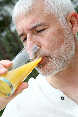 Senior man drinking orange juice