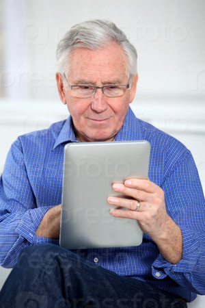 Elderly man connected on internet with electronic tab