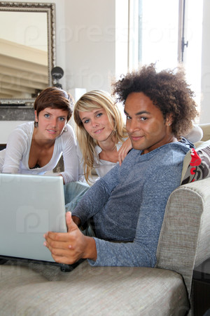 Group of friends sitting in sofa with laptop computer