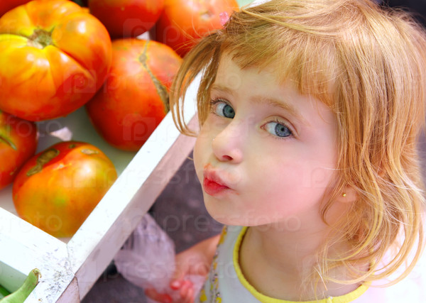 Hungry little girl gesturing in market tomatoes vegetables shop