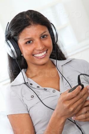 Beautiful latin girl listening to music with headphones